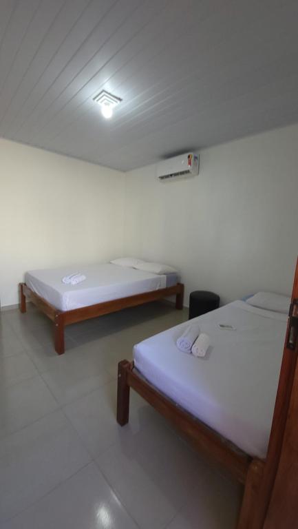 a room with two beds in a room with a ceiling at Aloha Suites in Barra de São Miguel