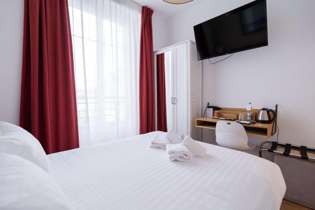 a bedroom with a white bed with red curtains at Best Western Hotel De La Plage Saint Marc sur Mer in Saint-Nazaire