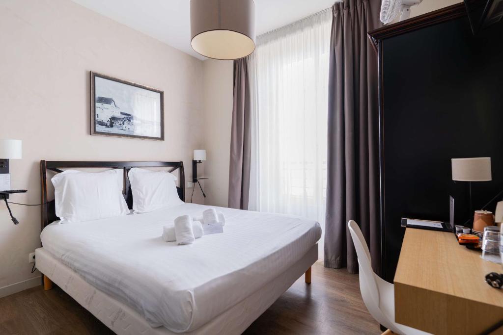 a hotel room with a white bed and a desk at Best Western Hotel De La Plage Saint Marc sur Mer in Saint-Nazaire