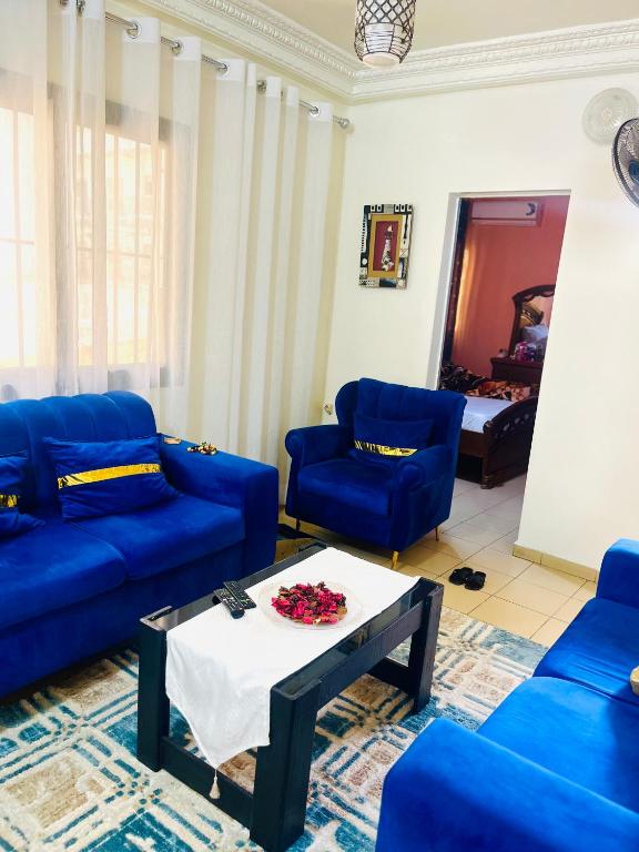 a living room with blue couches and a table at Studio meublé à fann hock in Dakar