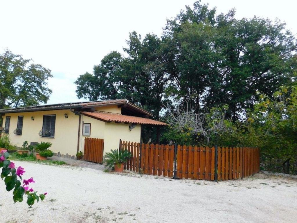 una pequeña casa con una valla delante de ella en Ferienhaus für 4 Personen 1 Kind ca 75 qm in Bottaccio, Latium Rom und Umgebung, en Castel di Guido