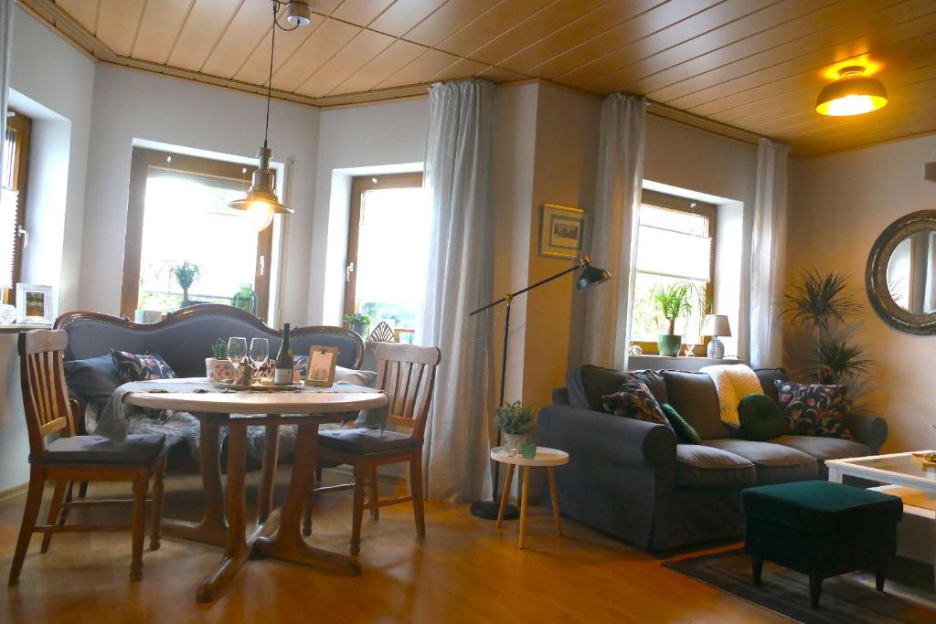 a living room with a table and a couch at Ferienwohnung Hüppelröttchen in Eitorf