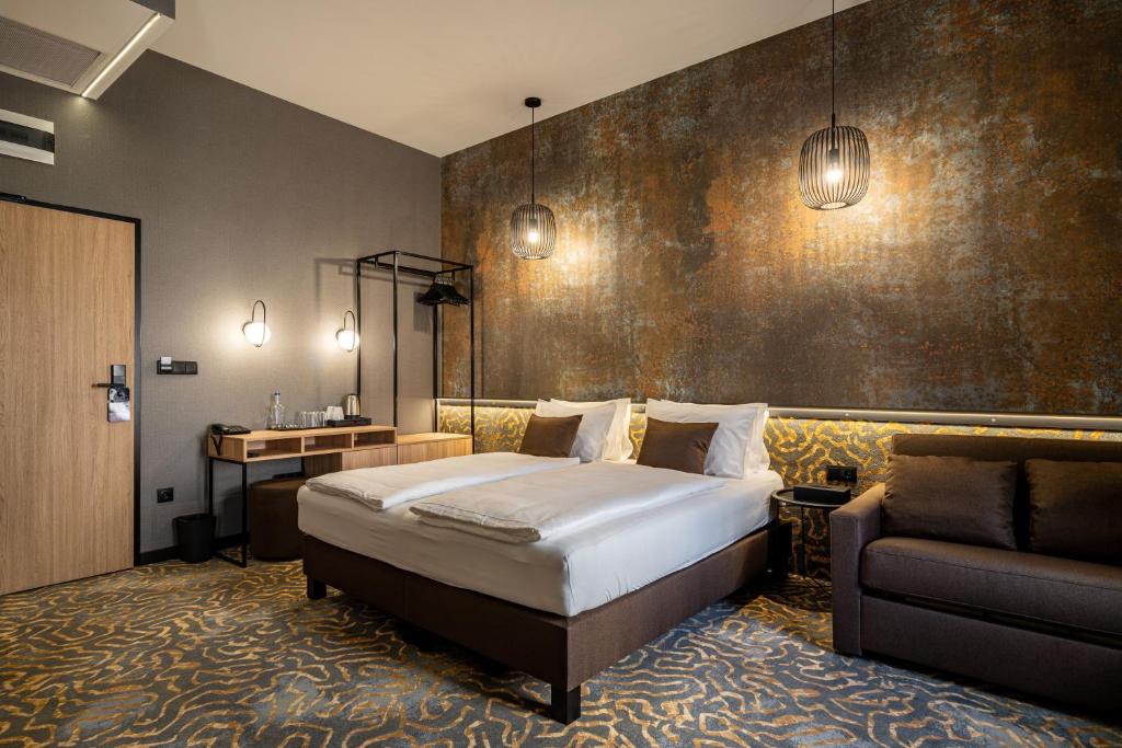 um quarto de hotel com uma cama e uma cadeira em URBAN HOTEL em Debrecen