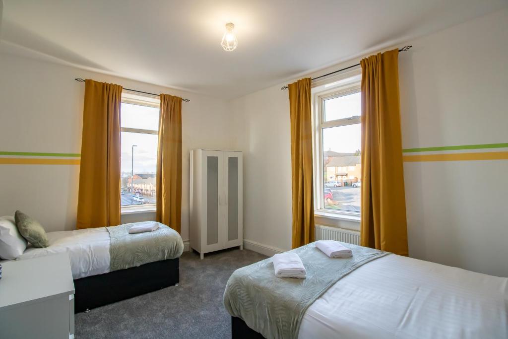 蓋茲黑德的住宿－HugeDiscounts Monthly offers，一间卧室设有两张床和两个窗户。
