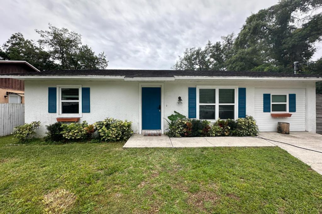 a white house with blue doors and a yard at BayCation in Tampa