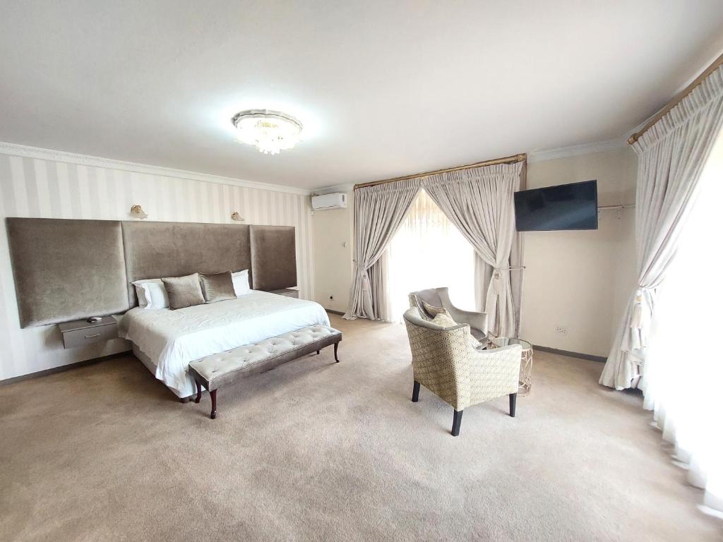 a bedroom with a large bed and a chair at View On 3rd in Centurion