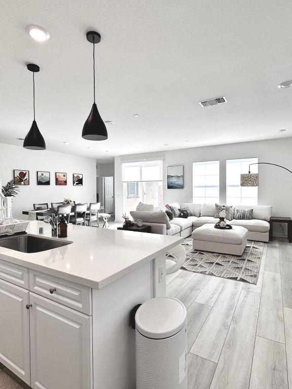 a white kitchen and living room with a couch at NEW Luxurious 5BR/3BATHES Home, Spacious and Retreat location with Modern Amenities in Ontario