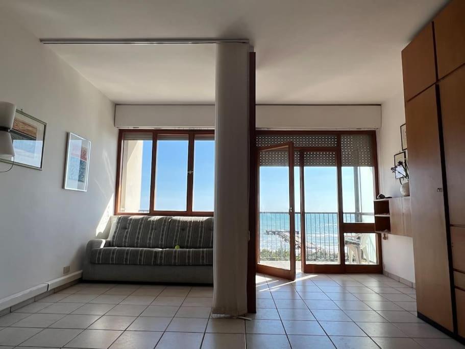 Una sala de estar con un sofá y vista al mar. en Monolocale lido di Venezia, en Lido de Venecia