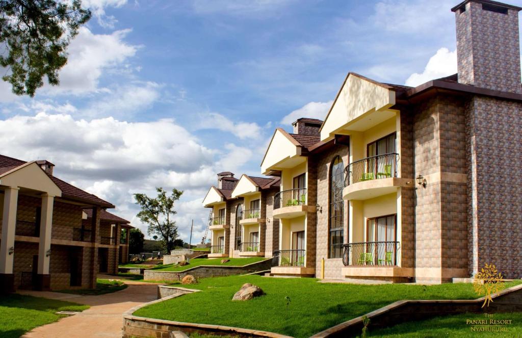 a row of apartment buildings with a green lawn at Panari Resort, BW Signature Collection in Nyahururu