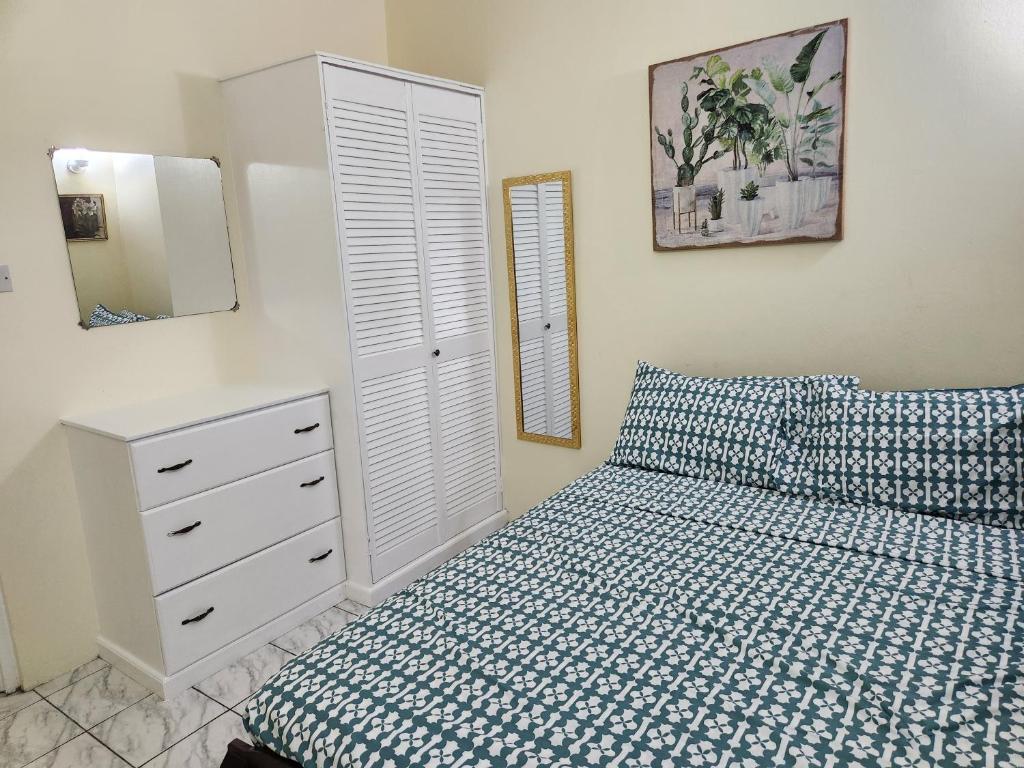 a bedroom with a bed and a dresser and a mirror at Sun Lover's Apartments in The Lime