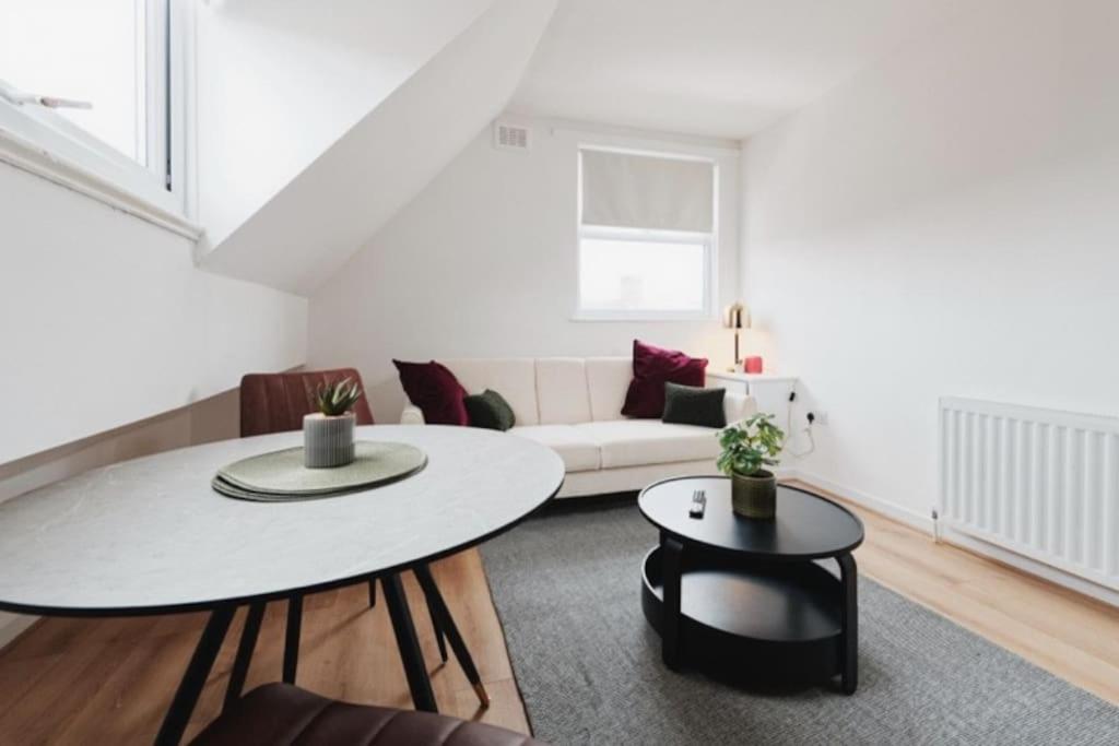 a living room with a table and a couch at Lamara Flat 3, Liverpool in Liverpool