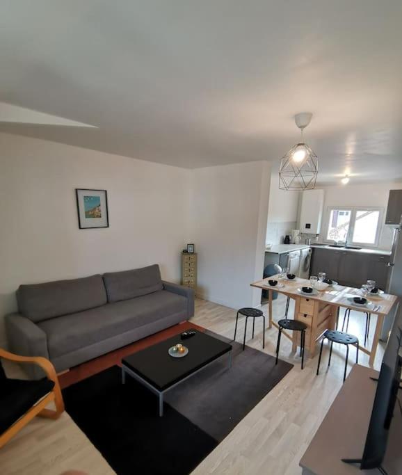 a living room with a couch and a table at Appartement Spacieux 80 m2 in Bobigny