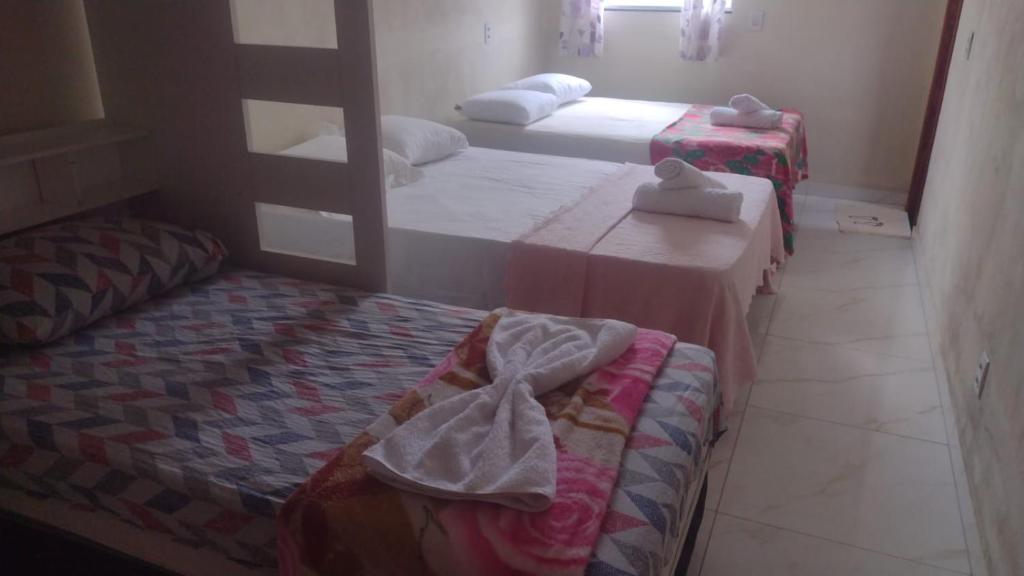 duas camas num quarto com duas mesas e toalhas em Aurora suites chapada Diamantina em Lençóis