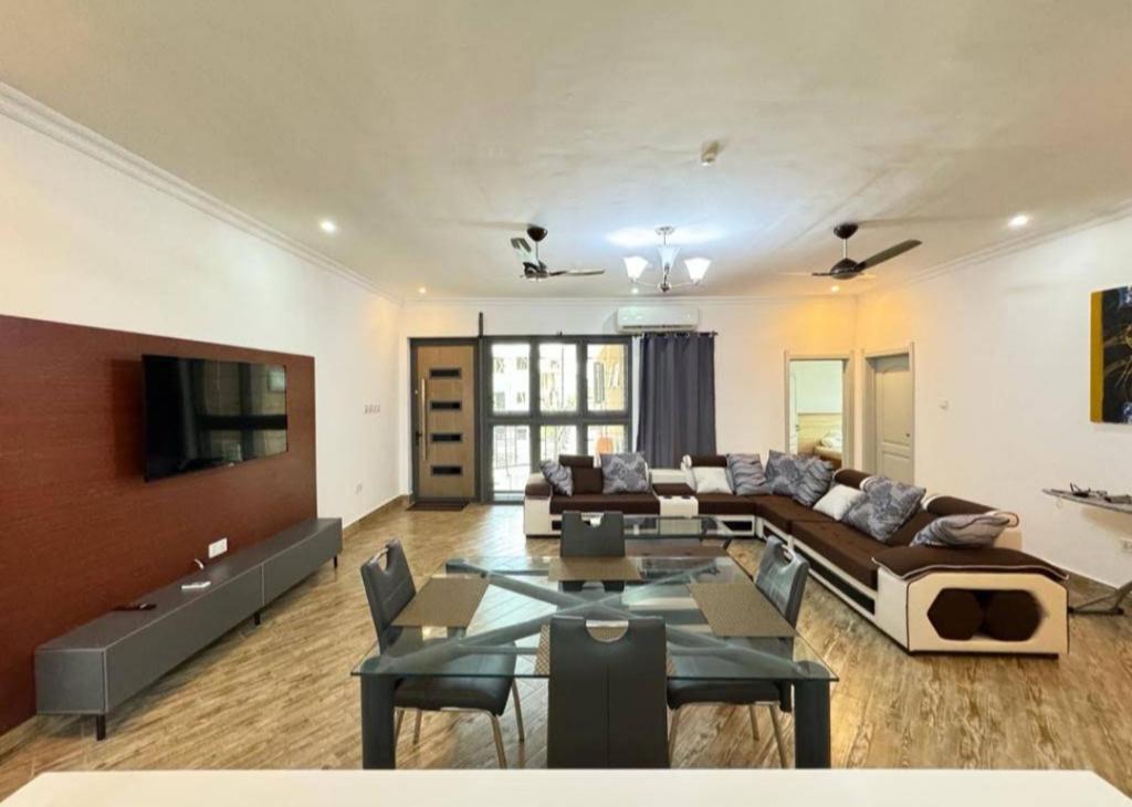 a living room with a couch and a table at Queen's 2 BDR Appartments Accra in Chantan