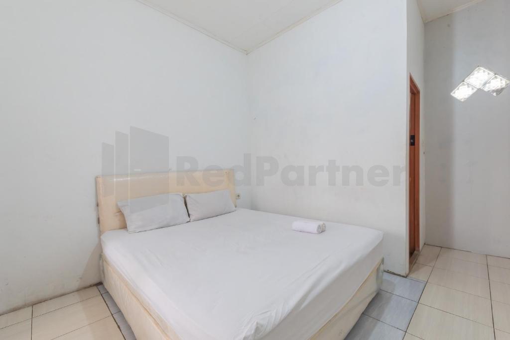 een kleine slaapkamer met een wit bed in een kamer bij Selaras Homestay Ciwidey in Nempel