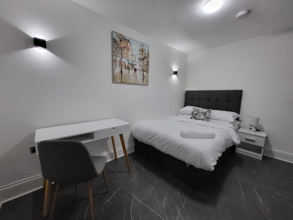 Biała sypialnia z łóżkiem, biurkiem i biurkiem w obiekcie Blackhorse Long Term Stay w Coventry
