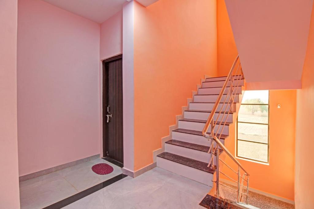 a staircase in a house with orange walls and a door at OYO Flagship Hotel Anand In in Nagpur