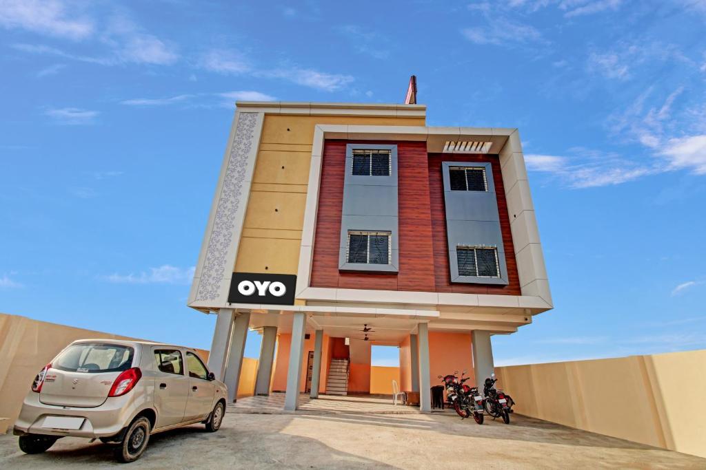una piccola casa con una macchina parcheggiata di fronte di OYO Flagship Hotel Anand In a Nagpur