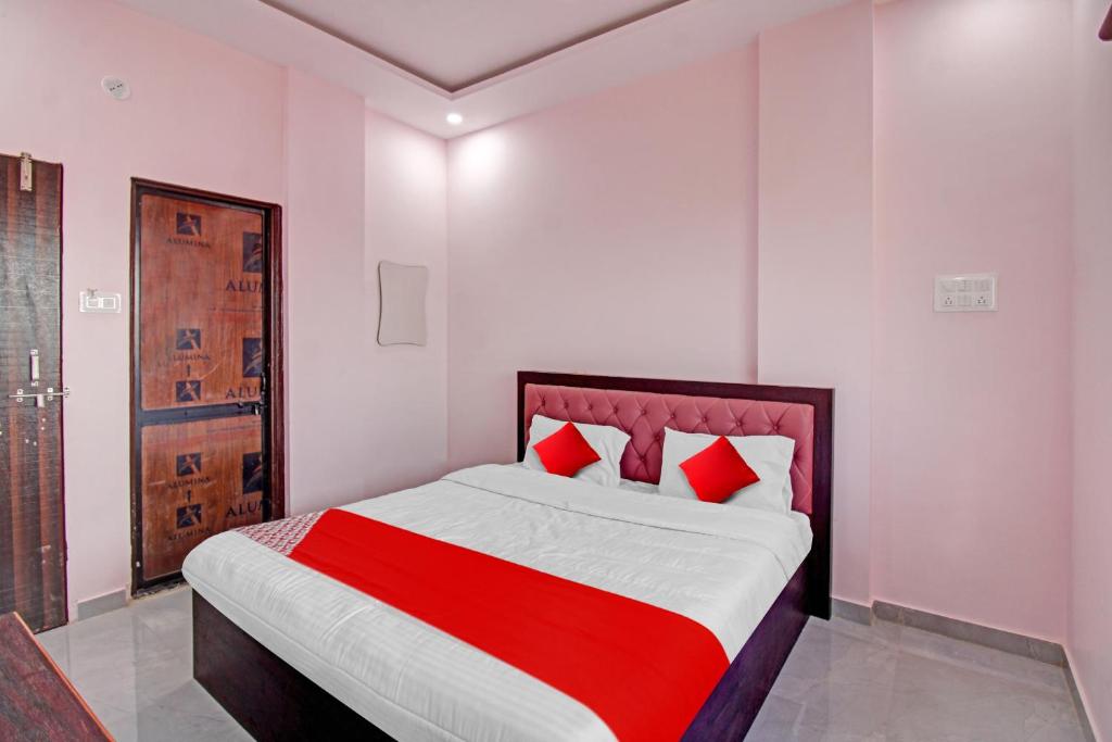 a bedroom with a large bed with red pillows at OYO Flagship Hotel Anand In in Nagpur