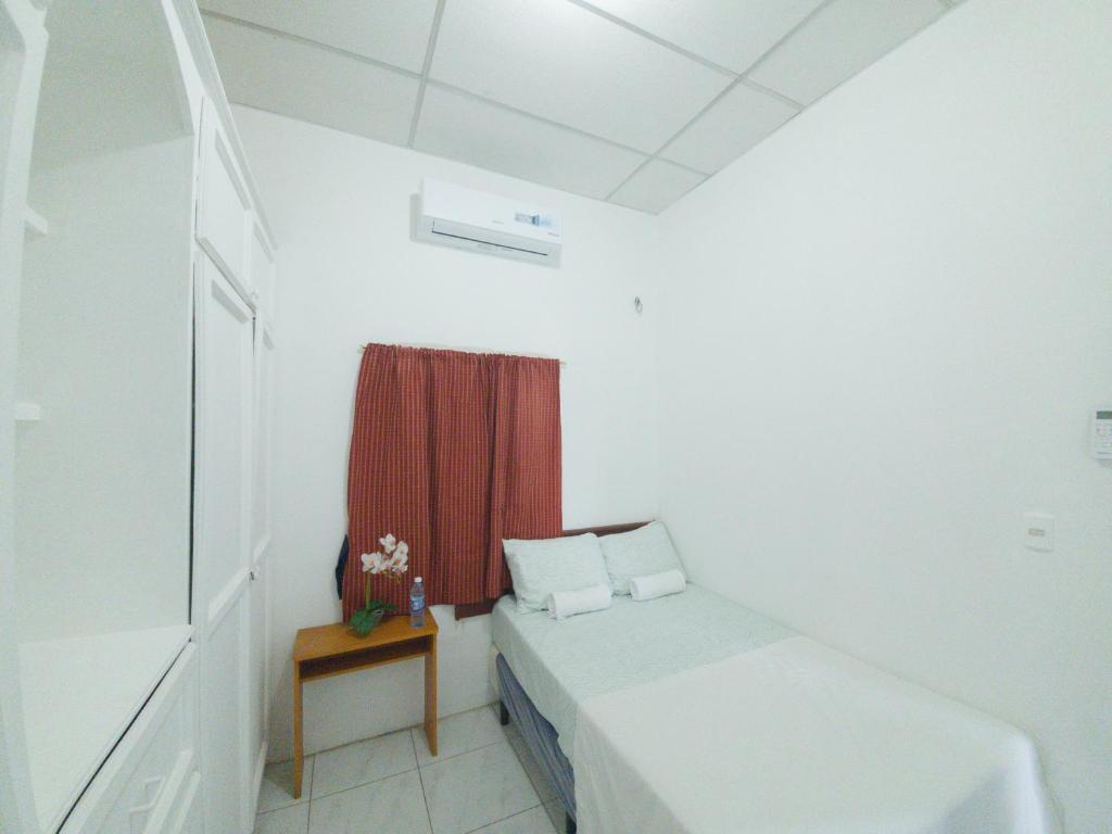 um pequeno quarto com uma cama e uma janela em Acogedora casa en Lomas de Bella Vista em La Unión