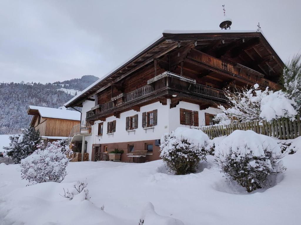 イッターにあるLitzlhof Kraftplatzlの雪の大きな木造家屋