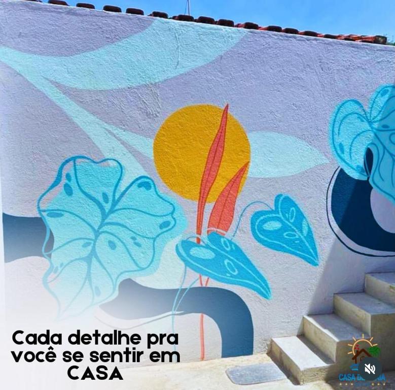 a wall with a painting of a kite on it at Casa de Praia - Suítes in Arraial do Cabo