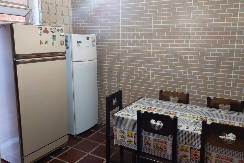 a kitchen with two refrigerators and a table and chairs at Casa da Vovó Irene in Araruama