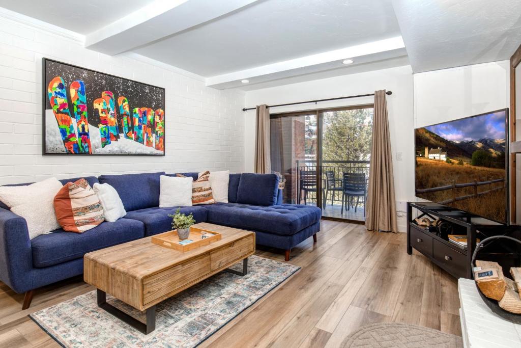 un soggiorno con un divano blu e un tavolo di PARK STATION 133 condo a Park City