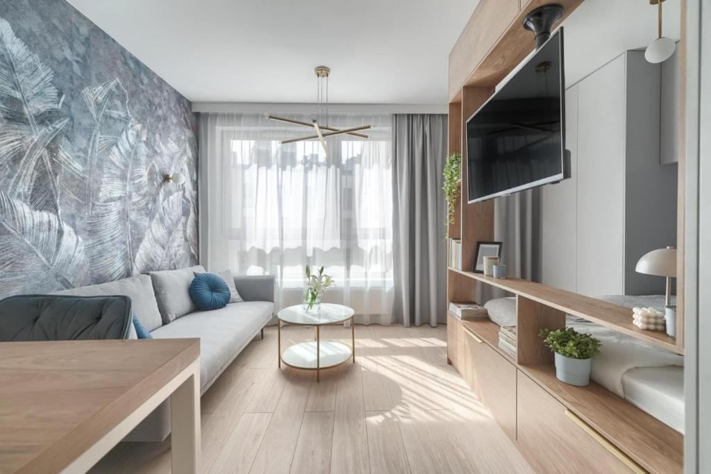 un soggiorno con divano e TV di CITYSTAY Arkona Residence a Stettino