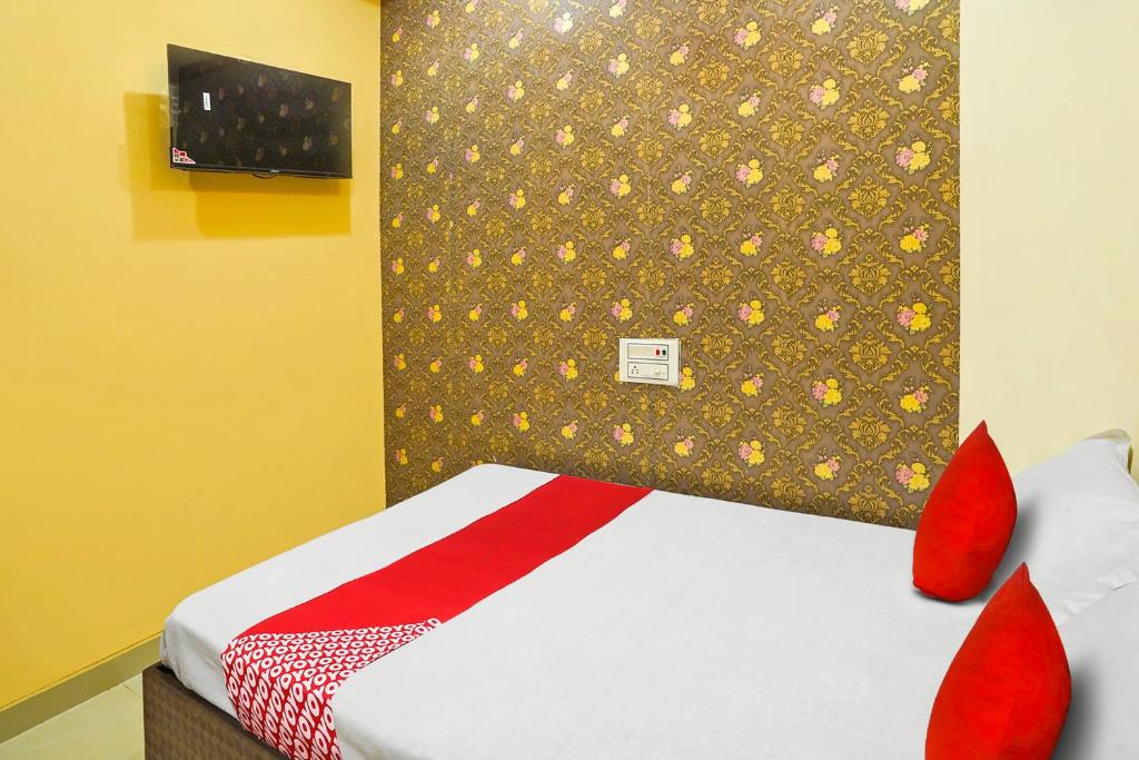 uma cama com almofadas vermelhas num quarto em OYO Flagship Hotel Sigdi & Restaurant em Jaipur