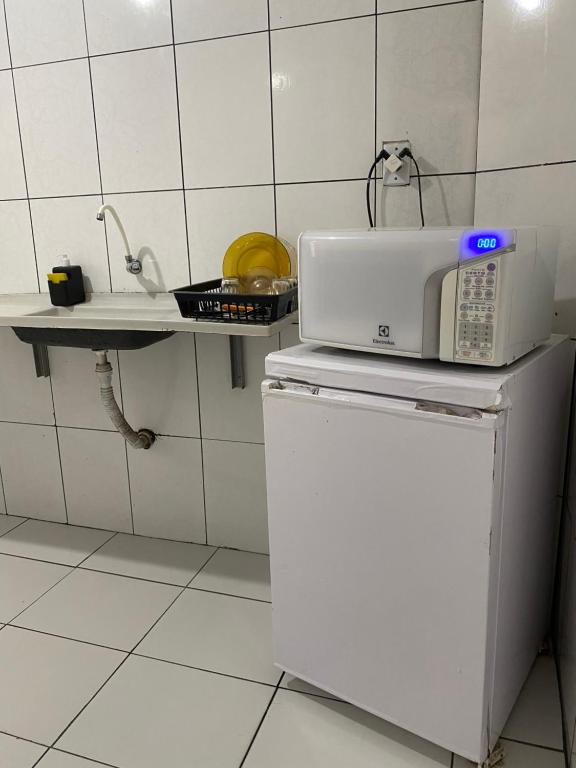 a microwave on top of a refrigerator in a kitchen at Hoje Apartamentos in Feira de Santana