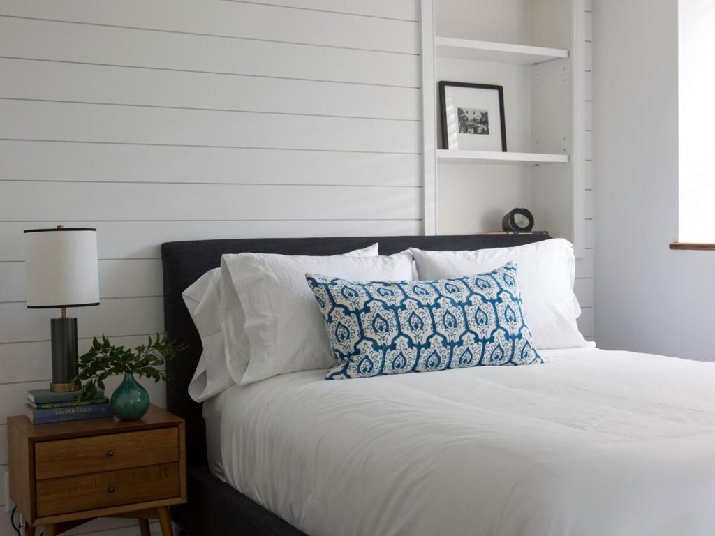 un letto con un cuscino bianco e blu di The Courtyard at CasaZoe a Charleston