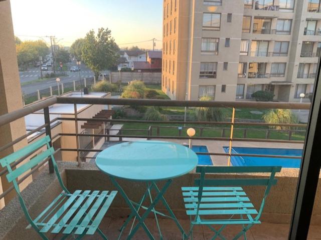 d'une table et de chaises sur un balcon avec vue sur la piscine. dans l'établissement DEPARTAMENTOS INVER LOURDES, à Los Ángeles