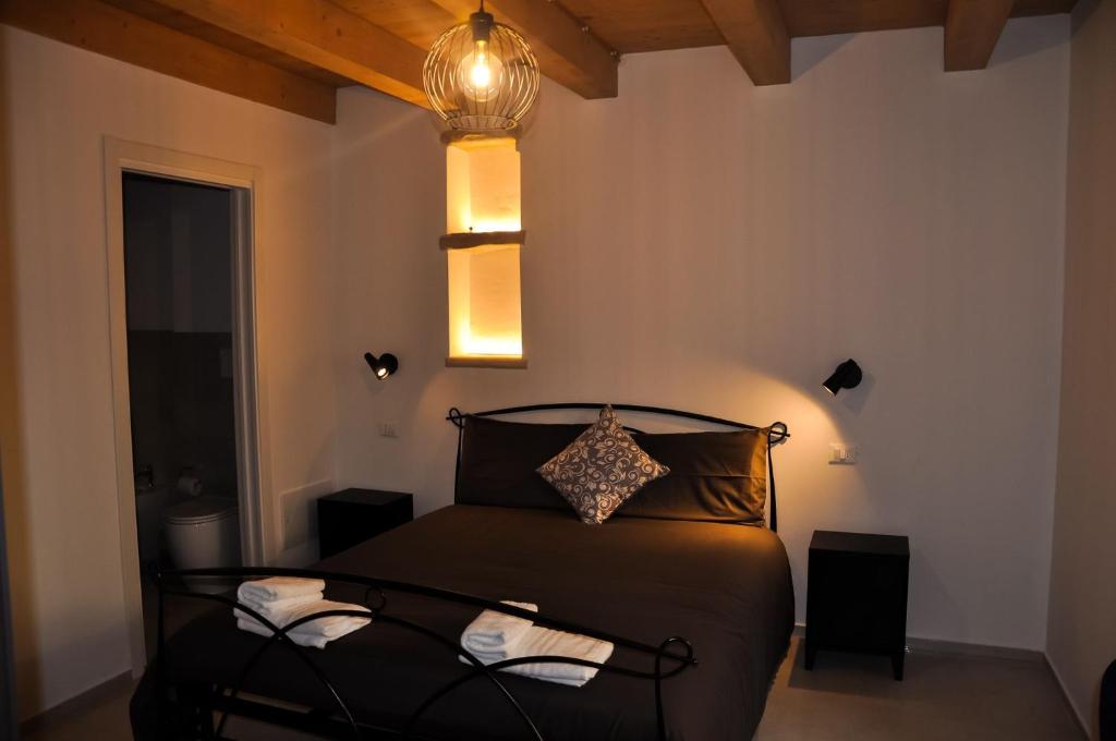 a bedroom with a black bed with lights above it at Bramante Suites Urbino in Urbino