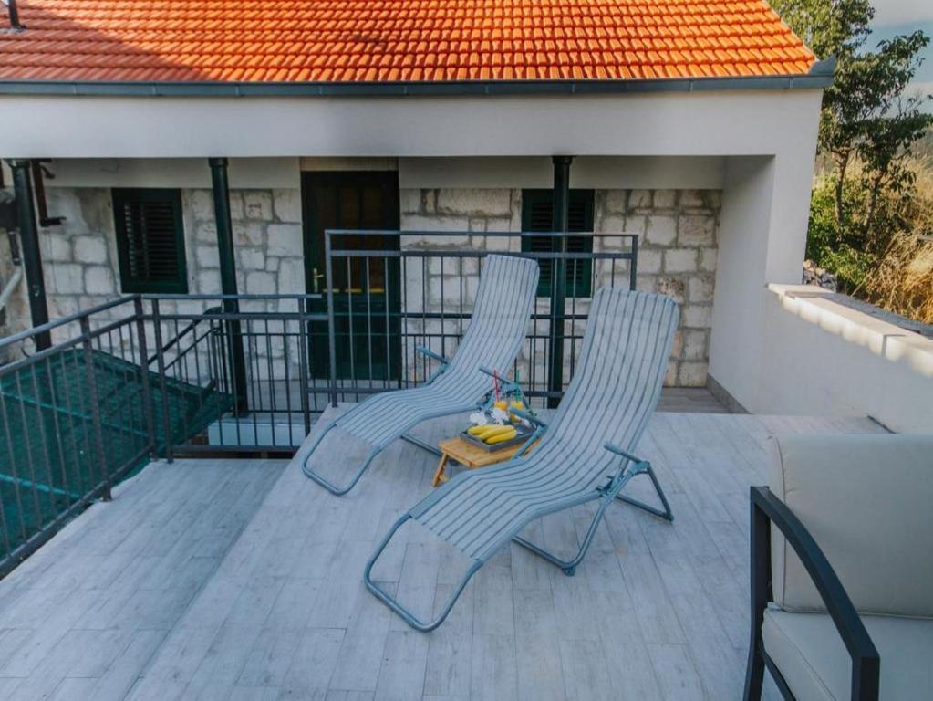 two chairs and a table on a balcony at Holiday house with a swimming pool Primorski Dolac, Zagora - 22831 in Prapatnica