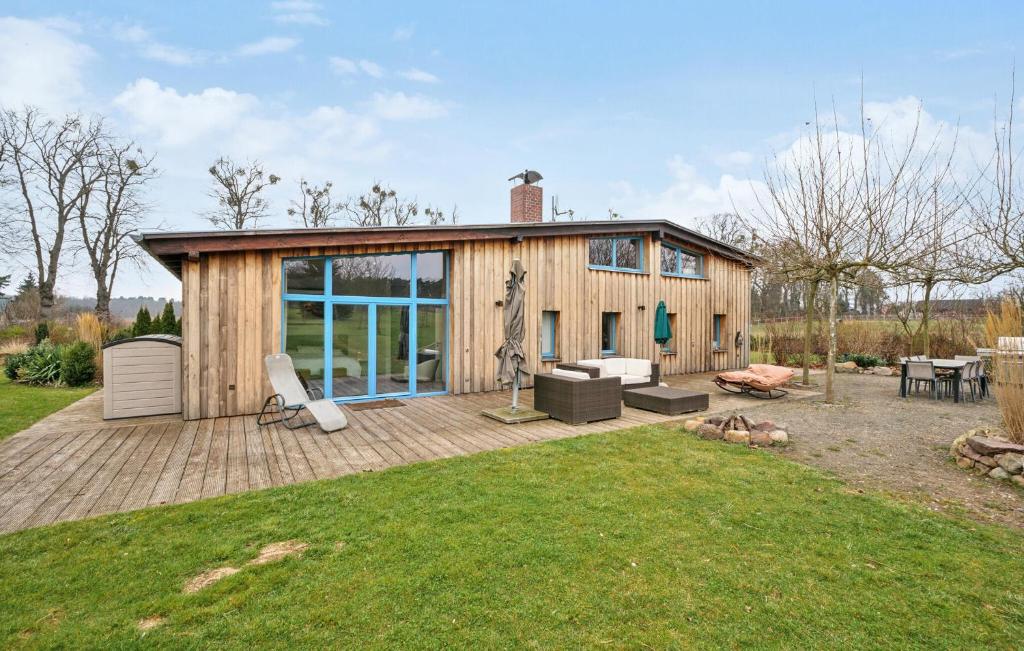 a small wooden house with a deck and a yard at Stunning Home In Templin With Sauna in Templin