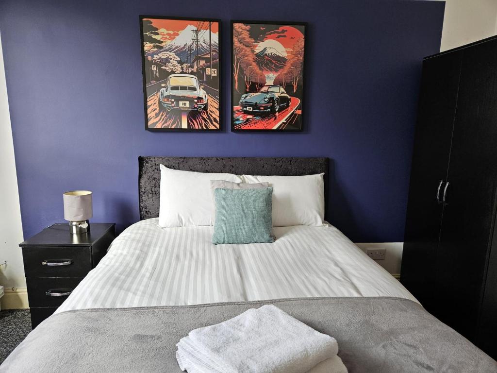 a bedroom with a bed with three pictures on the wall at Cannon Hill Shared House in Birmingham