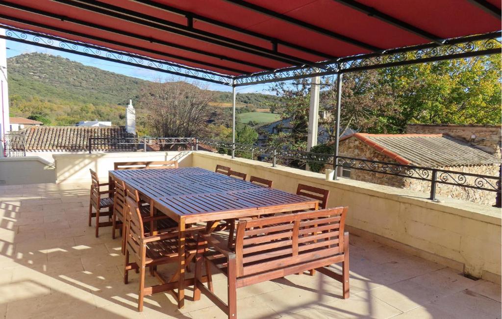 d'une table et de chaises en bois sur un balcon avec vue. dans l'établissement Nice Home In Faugères, à Faugères