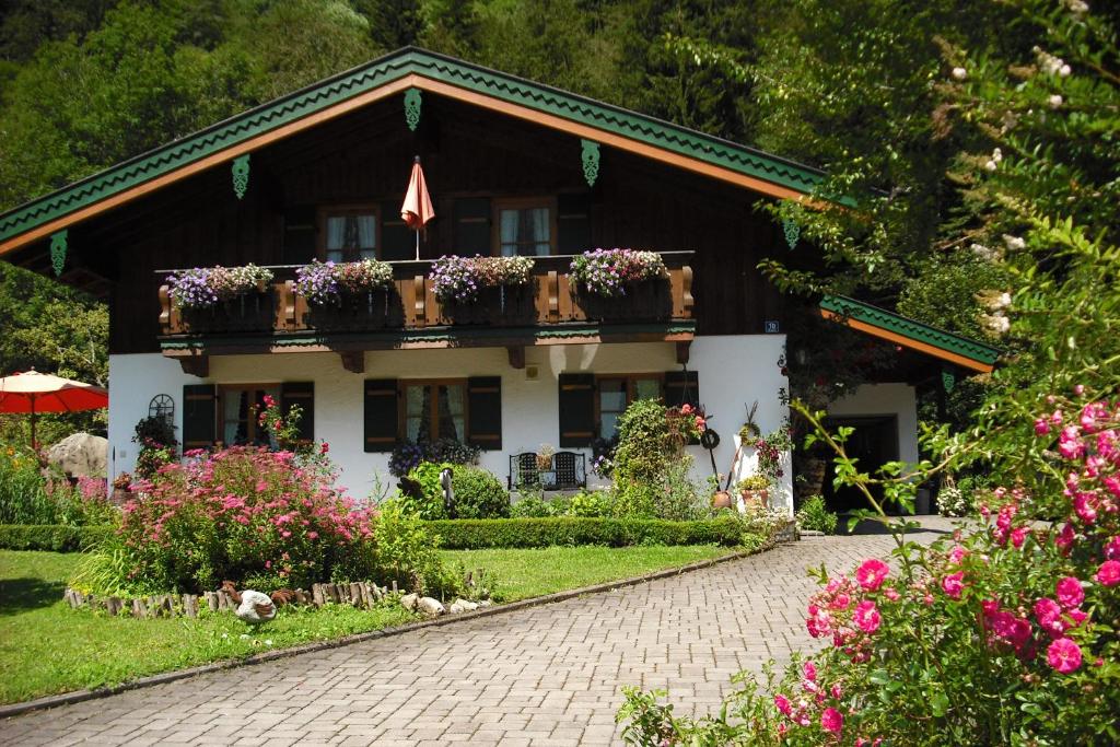 a house with flowers in front of it at Ferienwohnung Hinterreiter inkl. Chiemgaukarte in Ruhpolding
