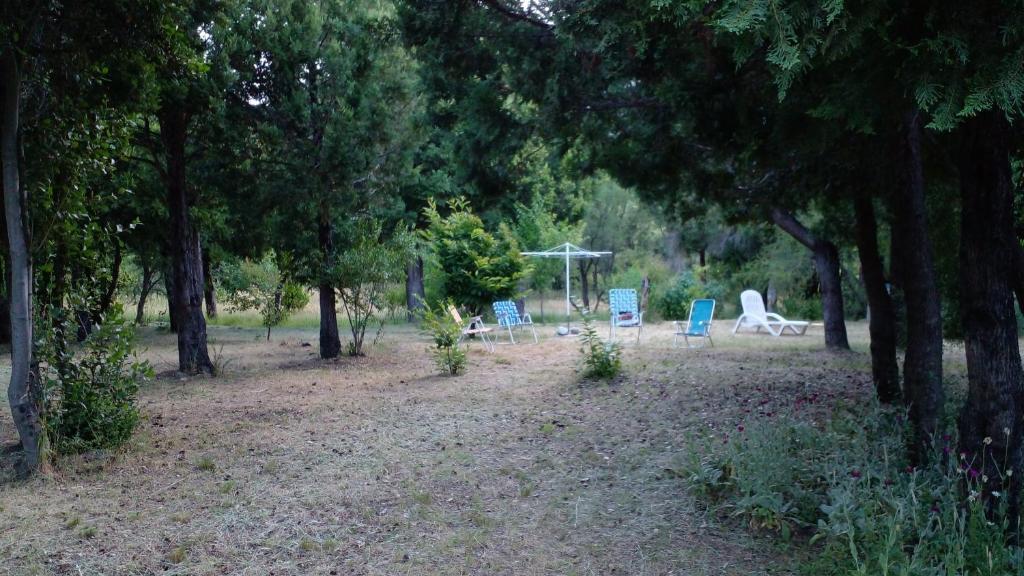 two chairs and a gazebo in a park with trees at chacra EL PORTAL in Epuyén