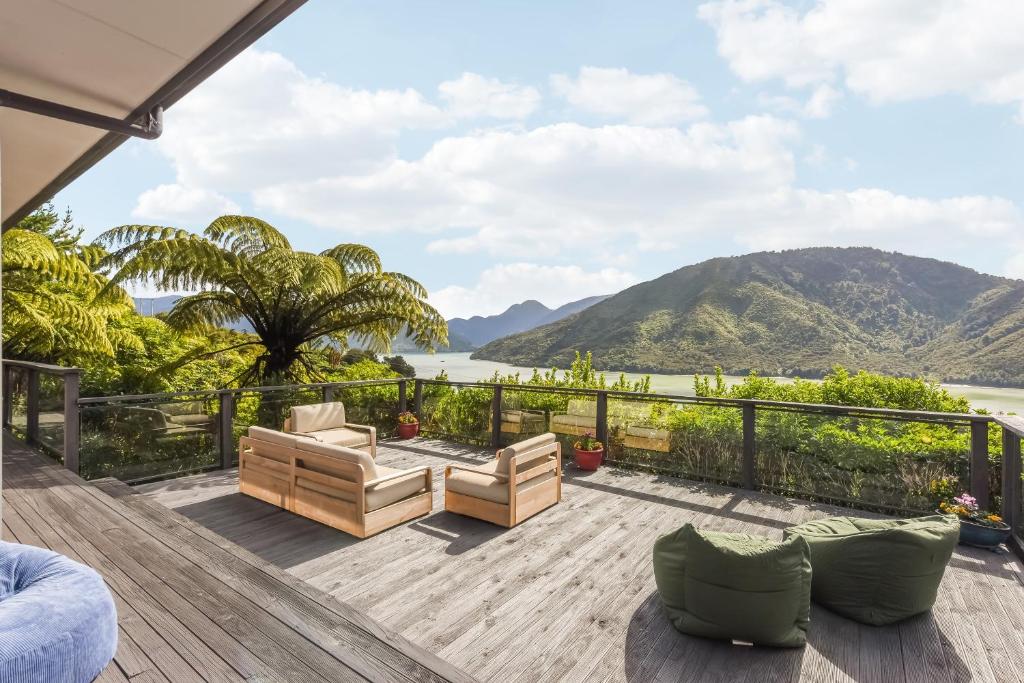 une terrasse avec vue sur l'eau et les montagnes dans l'établissement Tepuia Daze - Havelock Holiday Home, à Picton