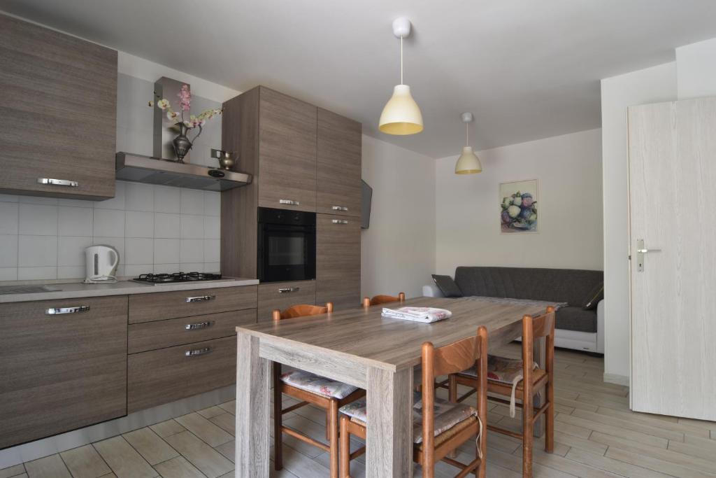 a kitchen with a wooden table and some chairs at Agritur il Torchio in Arco