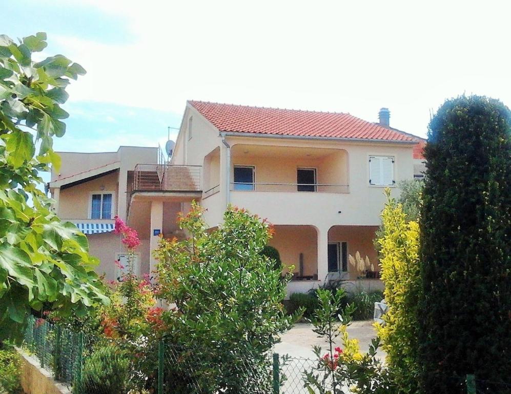 una casa grande con una valla delante en Apartments Jadranica, en Murter