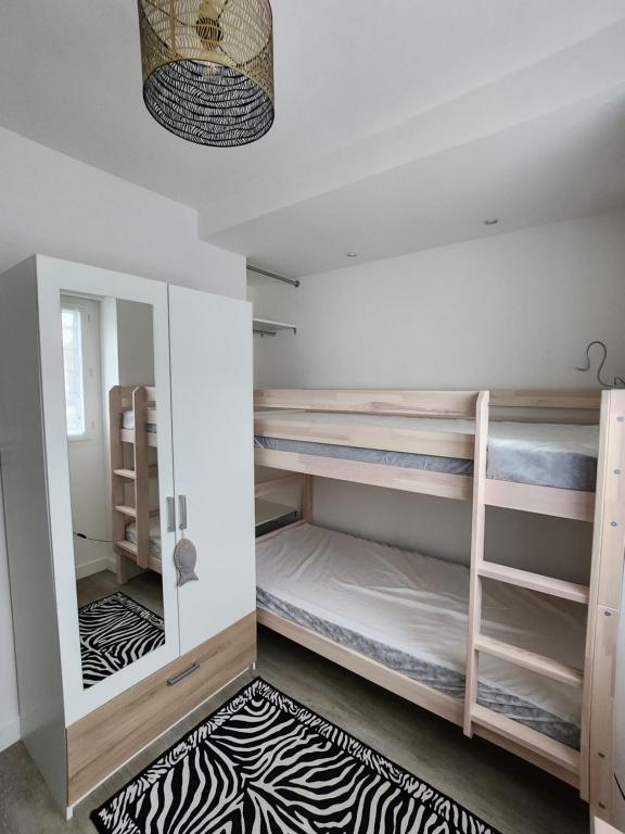 een kamer met een stapelbed en een tapijt bij Appartement vue mer in Saint-Georges-de-Didonne