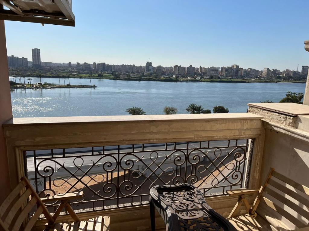 a balcony with a chair and a view of a river at شقة فندقية على النيل مباشر بالمعادى ٣ غرف ٣ حمام in Cairo