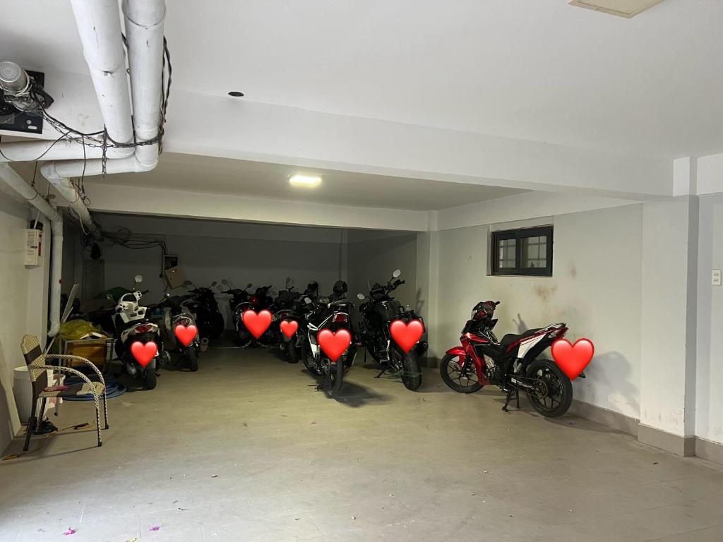 um grupo de motocicletas estacionados numa garagem com balões de coração em Tony's House Hotel Mũi Né em Ấp Thiện Phước