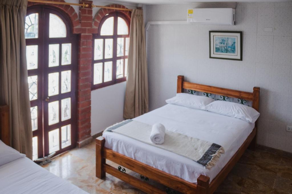 1 dormitorio con 2 camas y 2 ventanas en HOSTAL CASA TIO POLI, en Cartagena de Indias