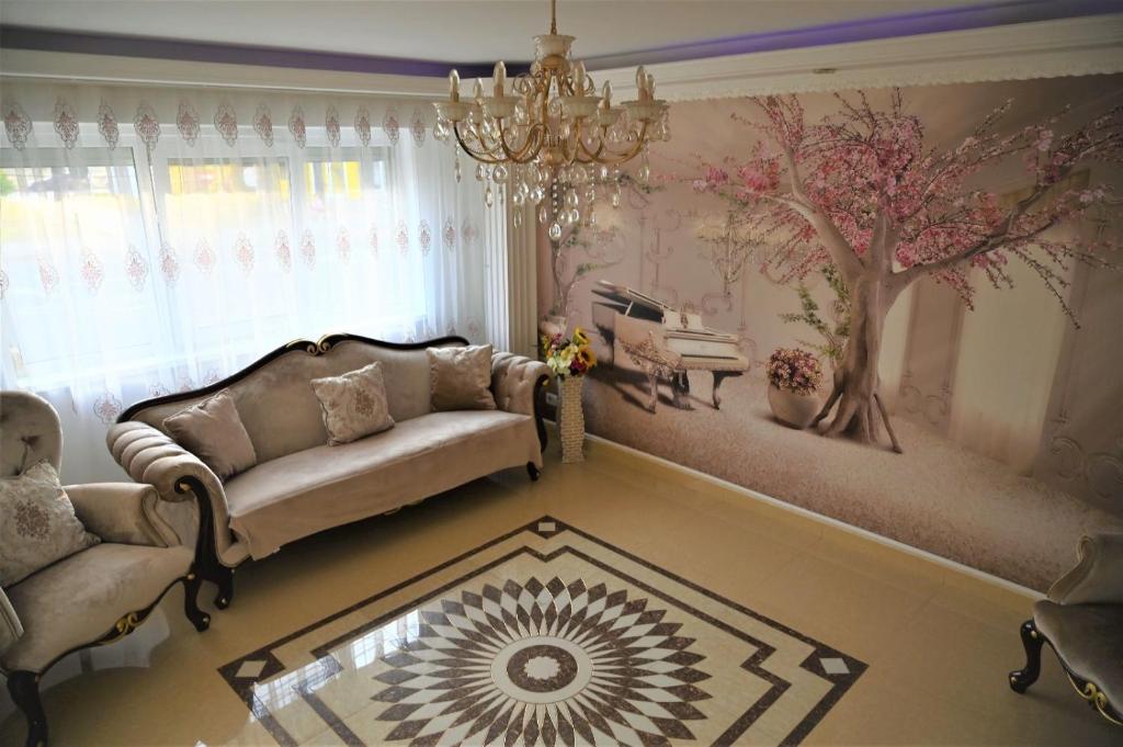 a living room with a couch and a tree mural at Apartament Mangalia in Mangalia