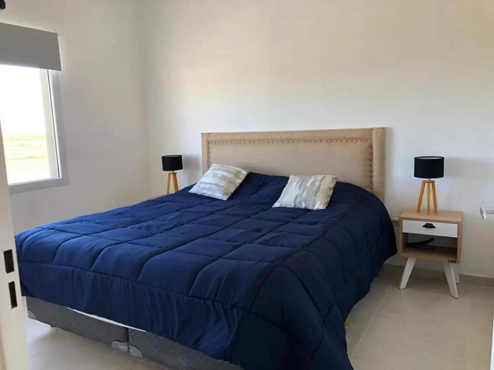 ein Schlafzimmer mit einem großen Bett mit einer blauen Decke in der Unterkunft Departamentos casa de mar in Playa Unión