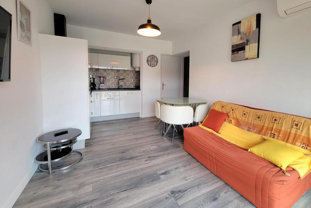 un salon avec un canapé et une cuisine dans l'établissement Charming love nest near the sea, à Fréjus